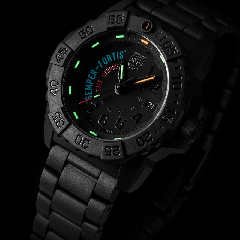 A black tactical-style LUMINOX WATCH שעון לומינוקס analog watch with a matching black metal link bracelet, featuring a dark dial with green, orange, and white markings and the text 'SEMPER FORTIS' and 'EVER STRONG