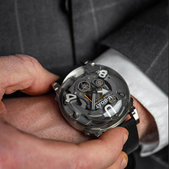 Person wearing a suit with a close-up of a mechanical U-BOAT watch on the wrist.